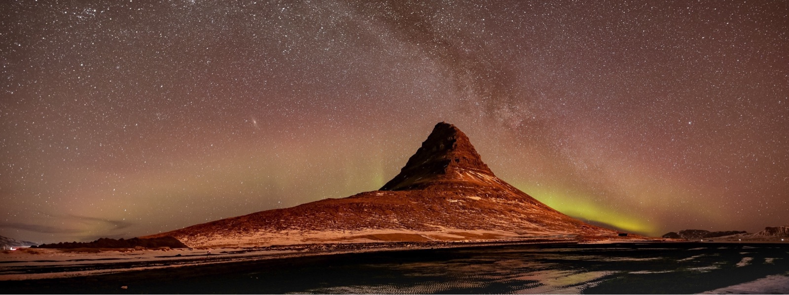 Aurora, the Milky Way, and the Andromeda galaxy over Kirkjufell, Iceland