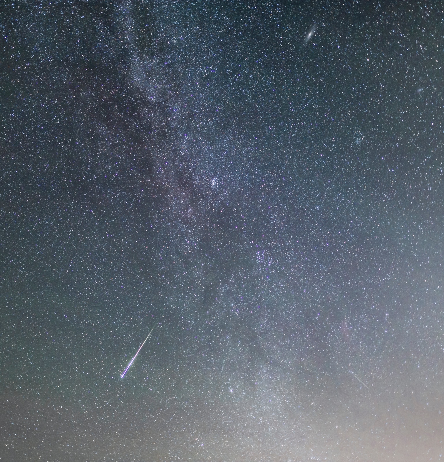 A meteor crossing the Milky Way, with the Andromeda galaxy above